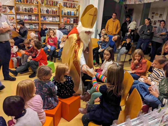 Nikolaus überreicht Kindern kleine Geschenke